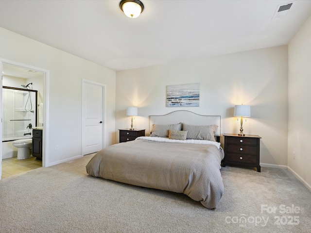 bedroom with visible vents, baseboards, light colored carpet, and ensuite bathroom