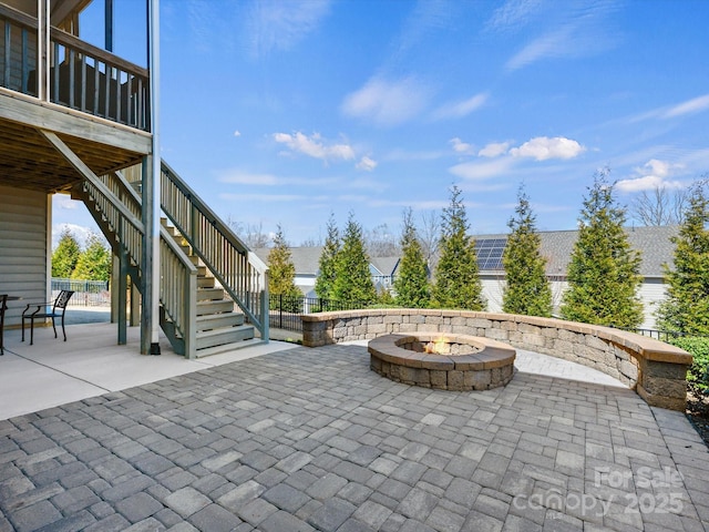 view of patio with stairway, fence, and an outdoor fire pit