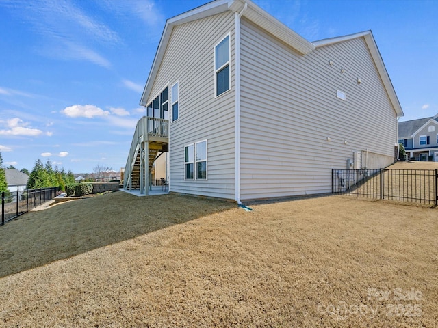 exterior space with stairway, a yard, and a fenced backyard