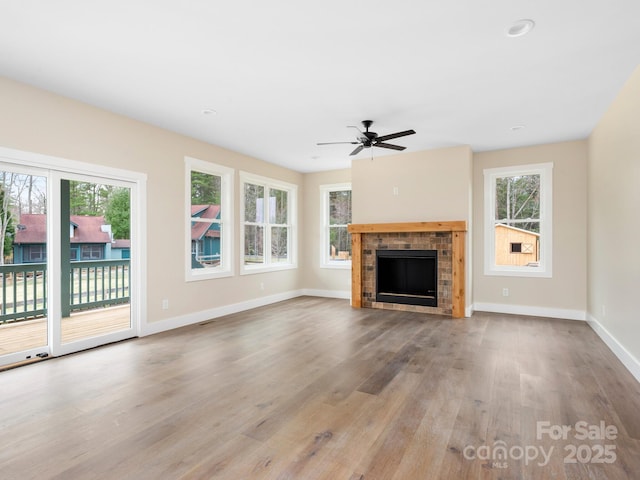 unfurnished living room with a brick fireplace, baseboards, ceiling fan, recessed lighting, and wood finished floors