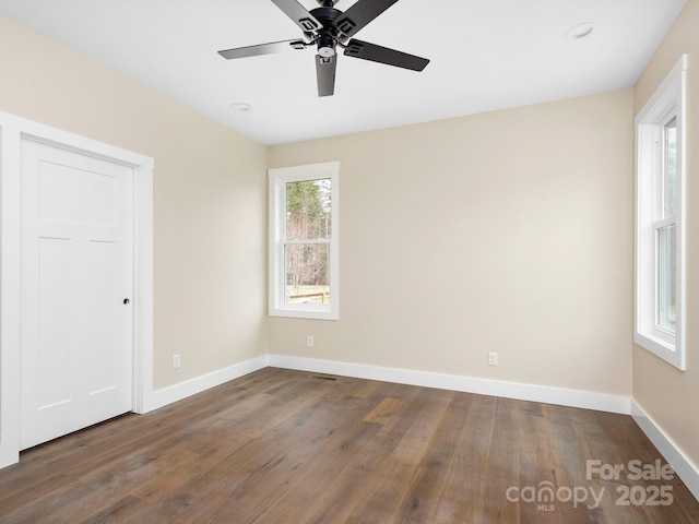 unfurnished room with baseboards, wood finished floors, and a ceiling fan