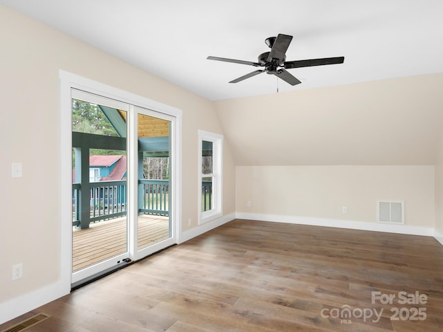 additional living space with visible vents, wood finished floors, a ceiling fan, and vaulted ceiling