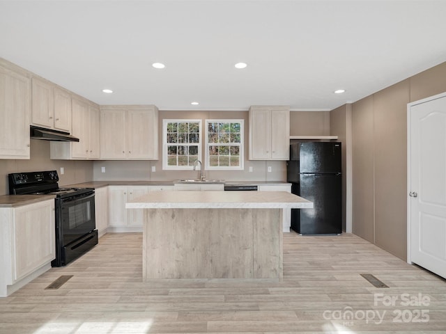 kitchen featuring a kitchen island, a sink, black appliances, light countertops, and under cabinet range hood