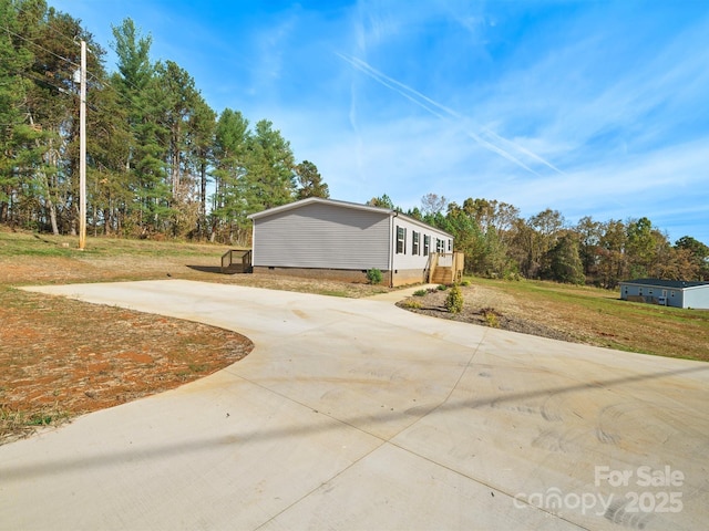 view of home's exterior featuring crawl space, a lawn, and driveway