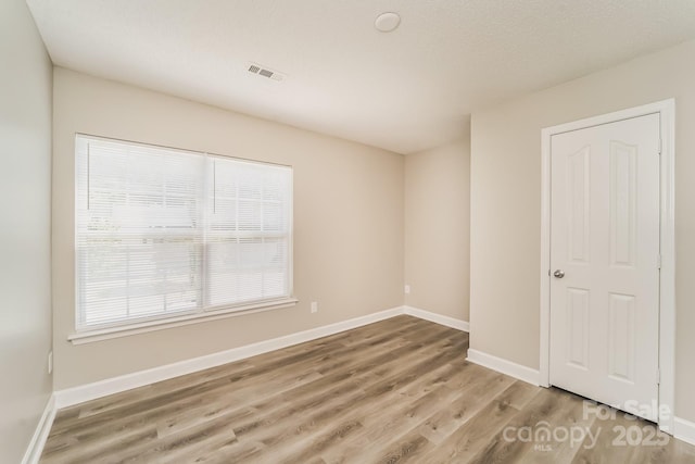 spare room featuring visible vents, baseboards, and light wood-style flooring