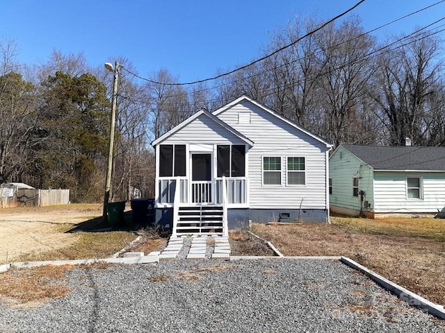 bungalow-style home with stairway, a sunroom, and crawl space