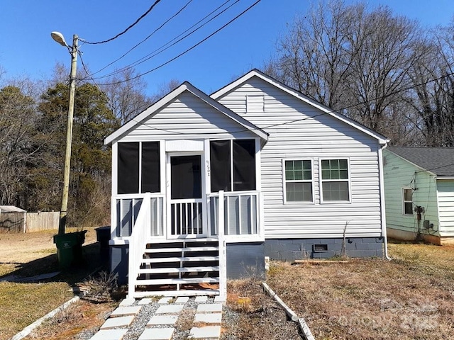 view of front of property with crawl space, fence, and a sunroom