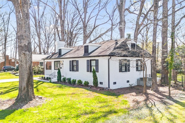 view of front of house with fence, a front yard, crawl space, brick siding, and a chimney
