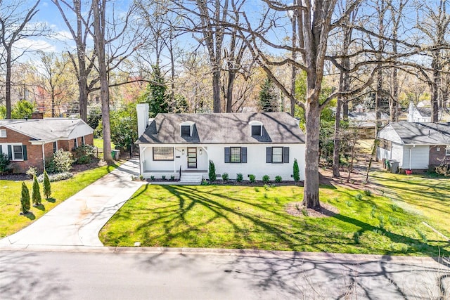 cape cod home featuring a front lawn, stucco siding, concrete driveway, and a chimney