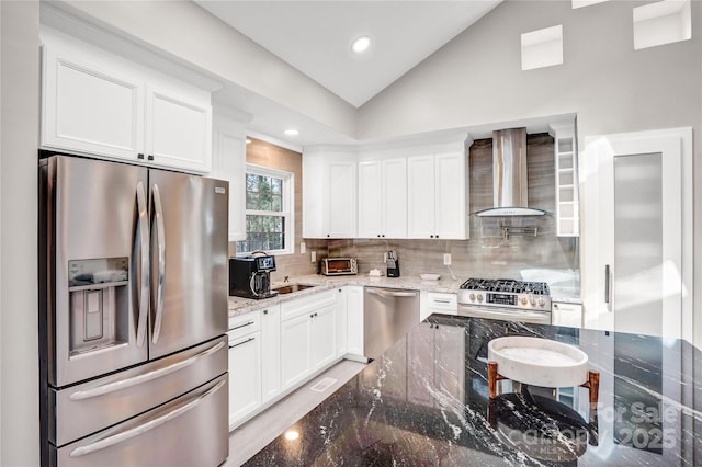 kitchen with a sink, tasteful backsplash, stainless steel appliances, wall chimney range hood, and vaulted ceiling