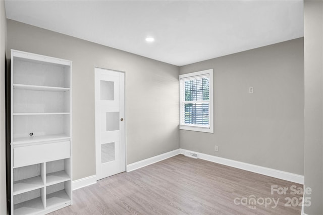 unfurnished bedroom featuring visible vents, baseboards, and wood finished floors