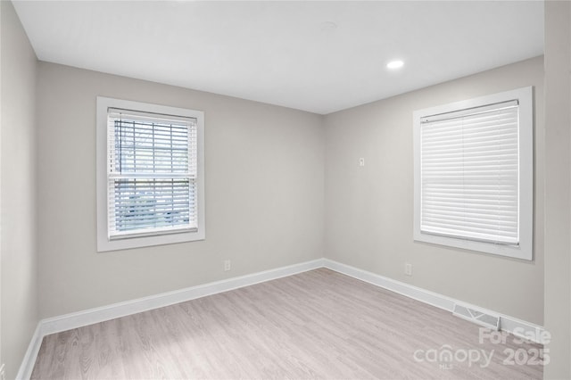 unfurnished room featuring recessed lighting, wood finished floors, and baseboards