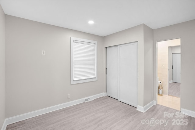 unfurnished bedroom featuring visible vents, wood finished floors, recessed lighting, a closet, and baseboards