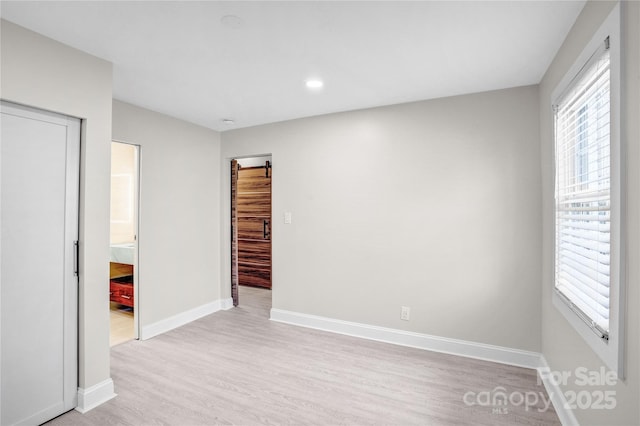 spare room featuring recessed lighting, baseboards, and light wood finished floors