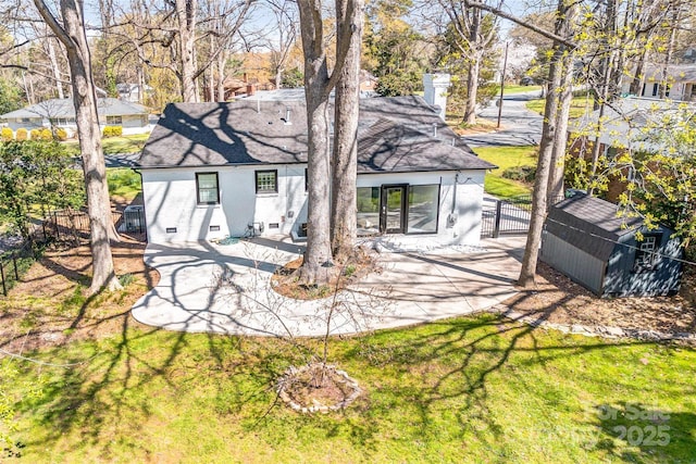back of property with a yard, a patio, an outbuilding, and fence