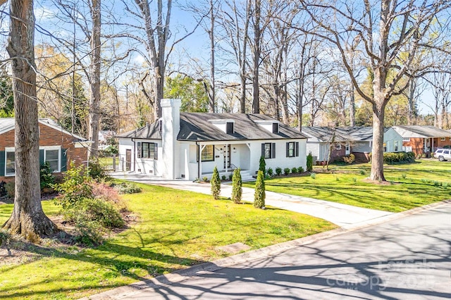 view of front of home featuring a front lawn, a residential view, and a chimney