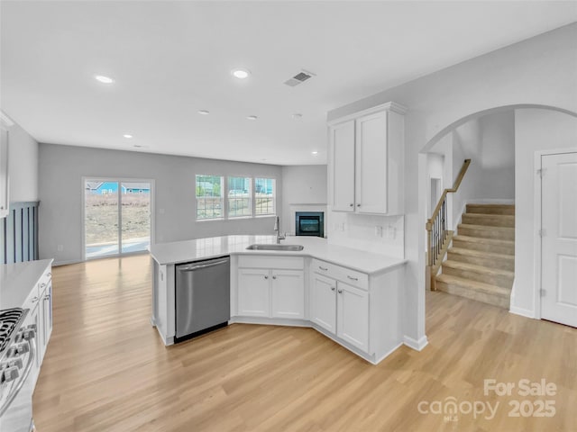 kitchen featuring visible vents, light countertops, stainless steel appliances, white cabinetry, and a sink