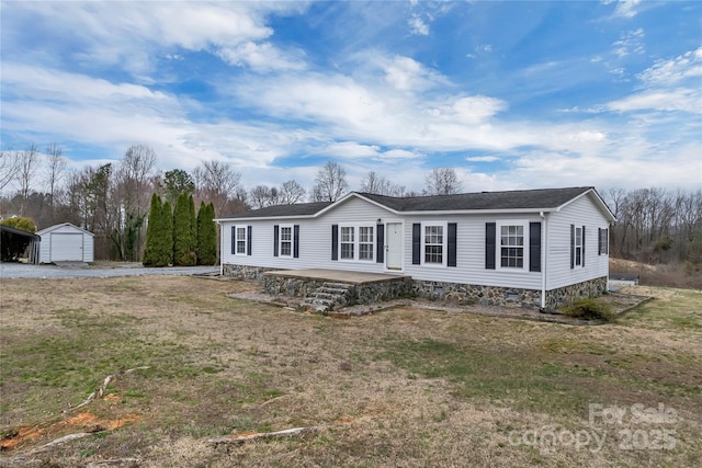 manufactured / mobile home with crawl space, gravel driveway, and an outdoor structure