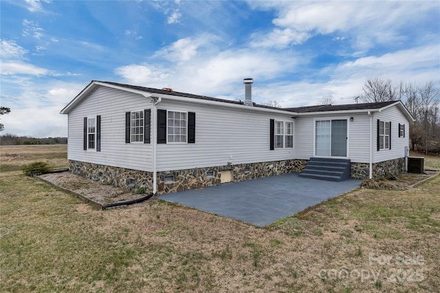 view of front of property featuring crawl space, entry steps, a front lawn, and a patio