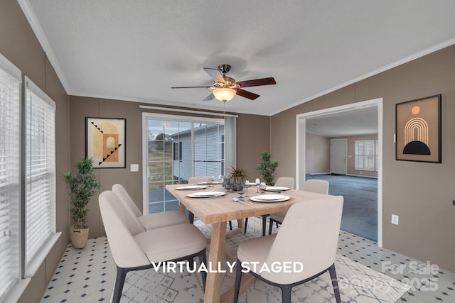 dining room featuring light carpet, a ceiling fan, crown molding, and a textured ceiling