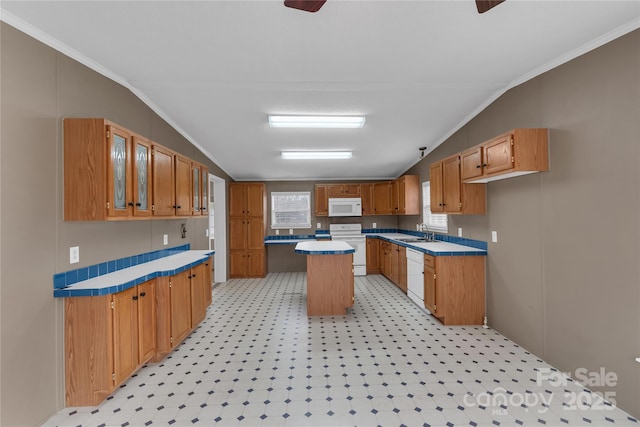 kitchen featuring a sink, white appliances, a kitchen island, and vaulted ceiling