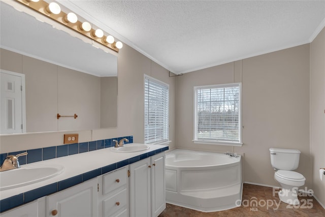 bathroom featuring a sink, a garden tub, a textured ceiling, and toilet