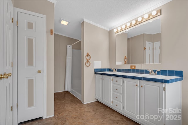 bathroom featuring a sink, a textured ceiling, a shower with shower curtain, and crown molding