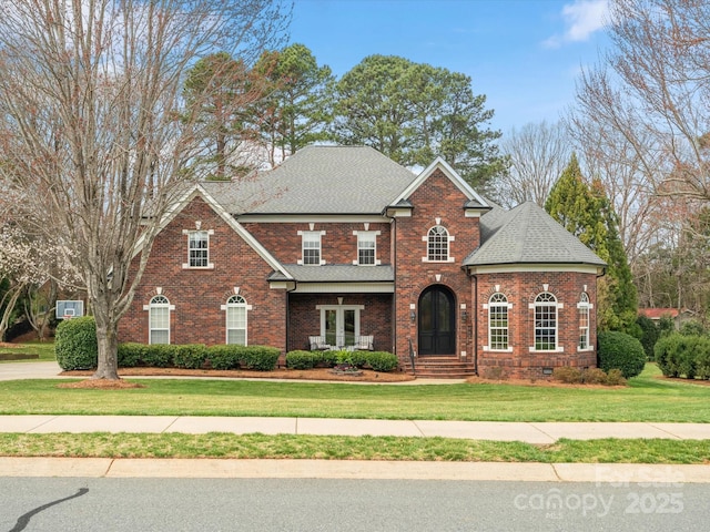 view of front of home featuring crawl space, brick siding, a front yard, and a shingled roof