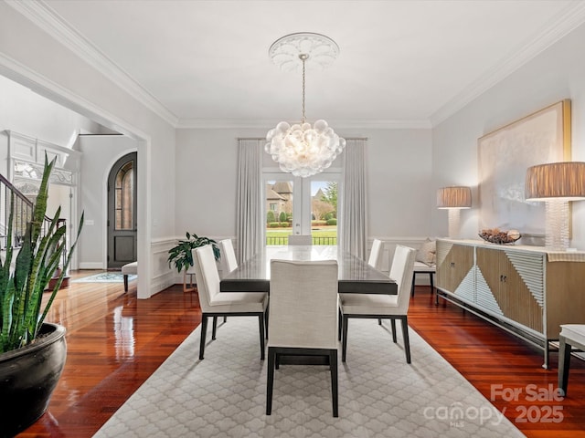 dining room with crown molding, an inviting chandelier, and wood finished floors