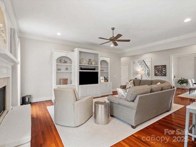 living area with crown molding, baseboards, ceiling fan, a fireplace, and wood finished floors