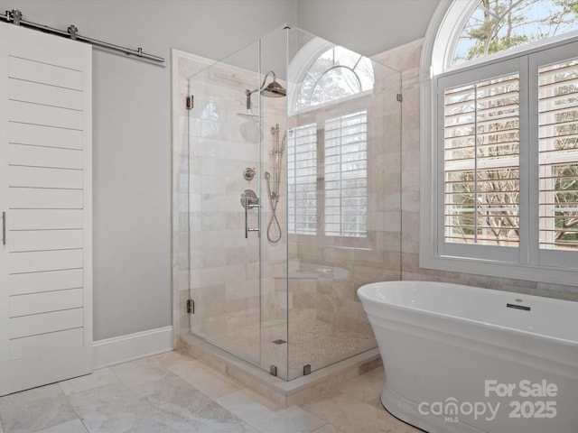 bathroom featuring marble finish floor, a stall shower, and a freestanding bath