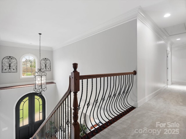 hallway with baseboards, carpet, a chandelier, and crown molding