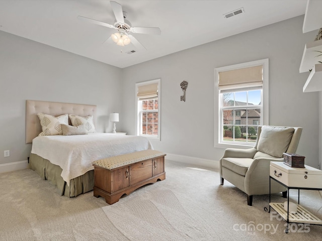 bedroom featuring visible vents, multiple windows, light colored carpet, and baseboards