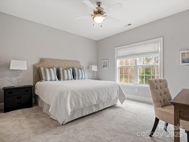 bedroom with a ceiling fan, light colored carpet, visible vents, and baseboards