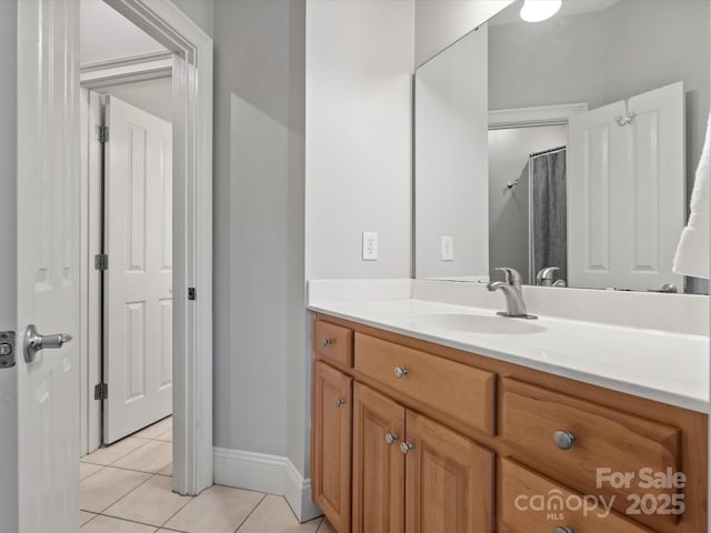 bathroom featuring tile patterned flooring, vanity, and baseboards