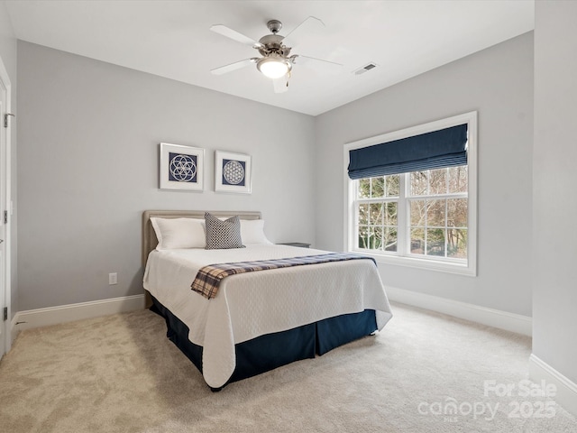 carpeted bedroom with visible vents, baseboards, and a ceiling fan