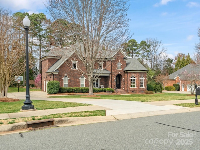 traditional home featuring a front lawn, a garage, brick siding, and curved driveway