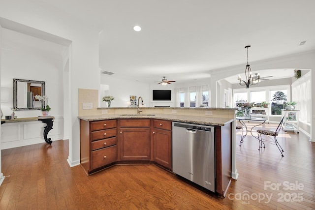 kitchen featuring ceiling fan with notable chandelier, a sink, stainless steel dishwasher, open floor plan, and brown cabinetry