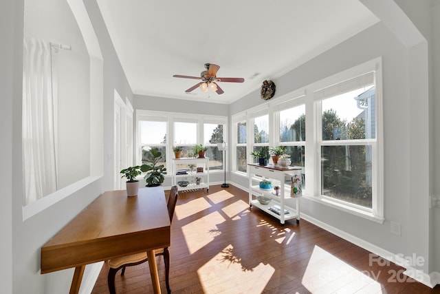 sunroom / solarium with arched walkways, a healthy amount of sunlight, and a ceiling fan