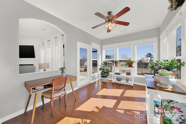 interior space with visible vents, ornamental molding, a ceiling fan, hardwood / wood-style floors, and arched walkways