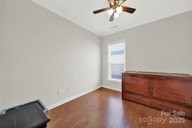 interior space with wood finished floors, visible vents, baseboards, ceiling fan, and crown molding