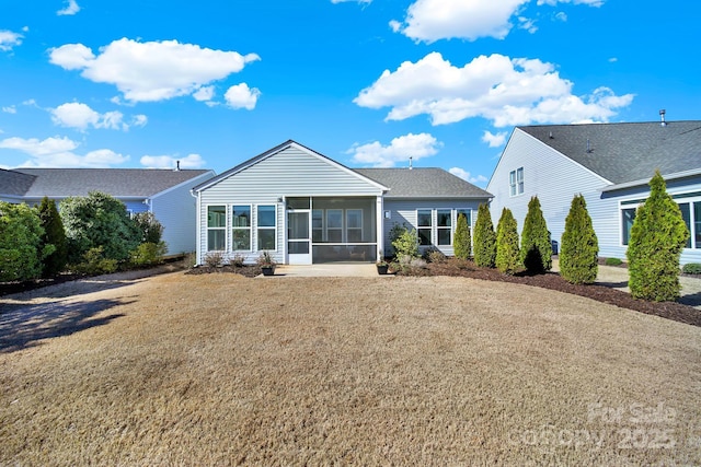 back of property with roof with shingles and a sunroom