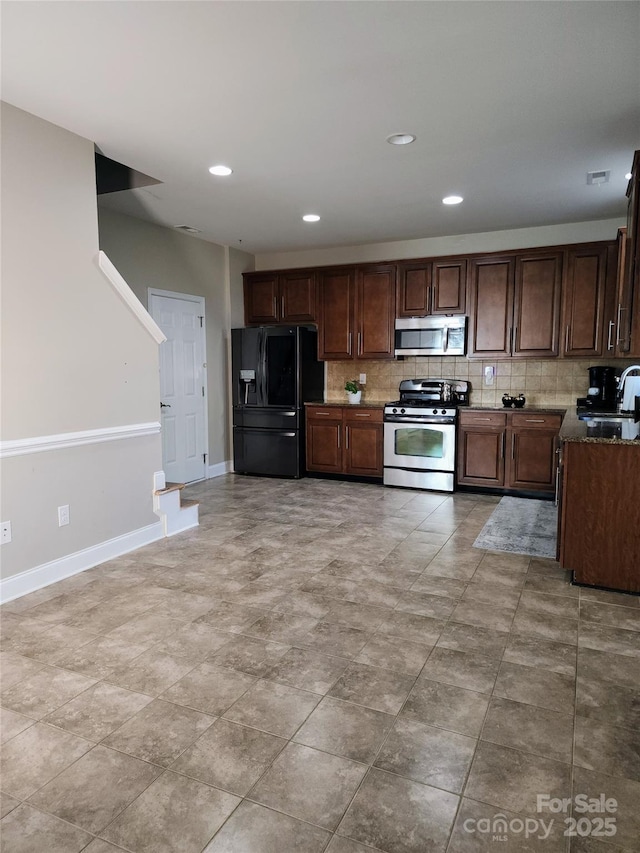 3500 Exbury Gardens Dr, Waxhaw, NC 28173 - kitchen with baseboards, recessed lighting, appliances with stainless steel finishes, a sink, and backsplash