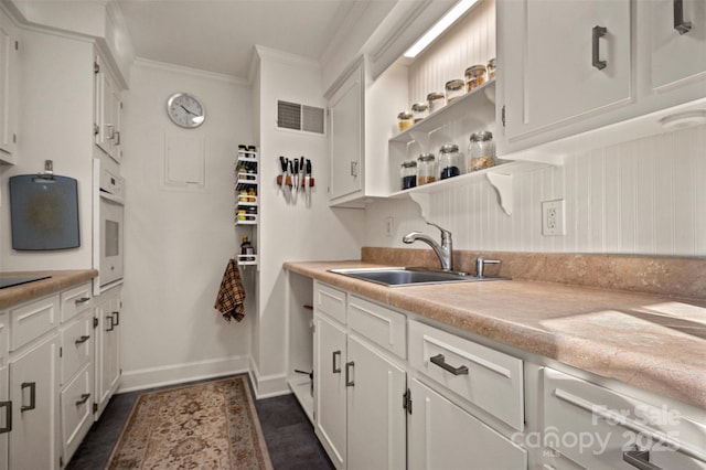 kitchen with visible vents, a sink, light countertops, white oven, and open shelves