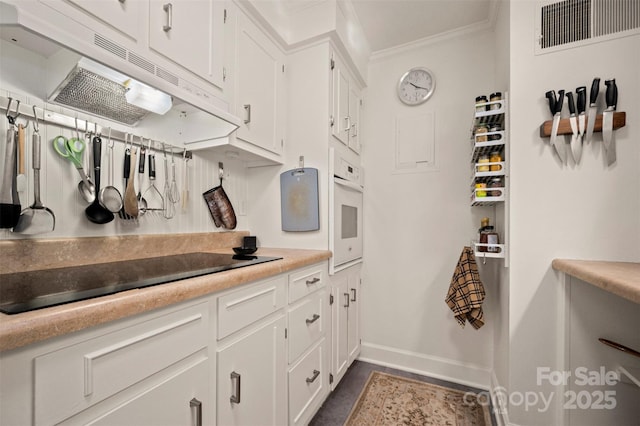 bathroom featuring visible vents, vanity, baseboards, and ornamental molding