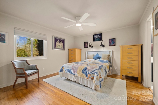 bedroom with light wood-style flooring, baseboards, ornamental molding, and a ceiling fan