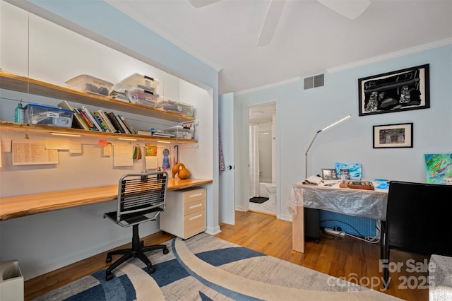 office with crown molding, light wood-style floors, and visible vents