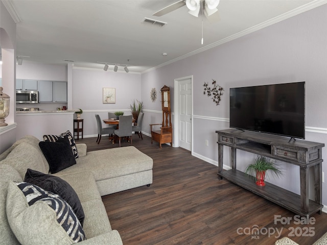 living area with ceiling fan, wood finished floors, visible vents, and ornamental molding