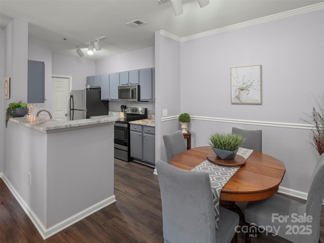 kitchen featuring visible vents, dark wood finished floors, a peninsula, gray cabinets, and appliances with stainless steel finishes