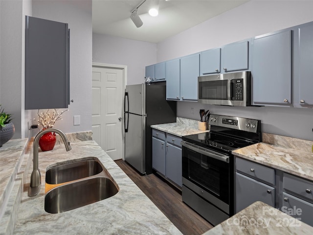 kitchen with gray cabinetry, dark wood-style floors, appliances with stainless steel finishes, and a sink